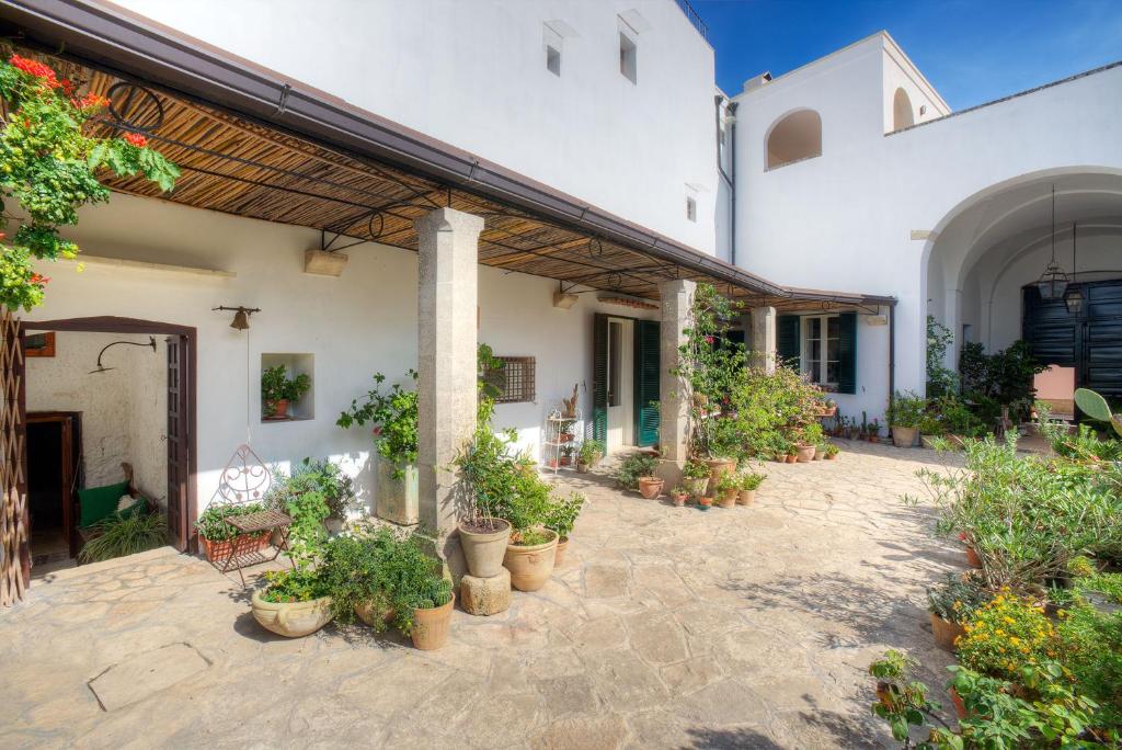 une cour d'une maison avec des plantes en pot dans l'établissement Casale del Forno, à Andrano