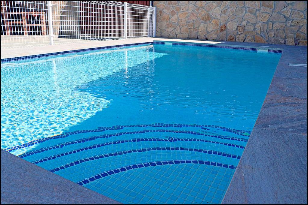 - une grande piscine revêtue de carrelage bleu dans l'établissement Chalet Ermita, à Conil de la Frontera