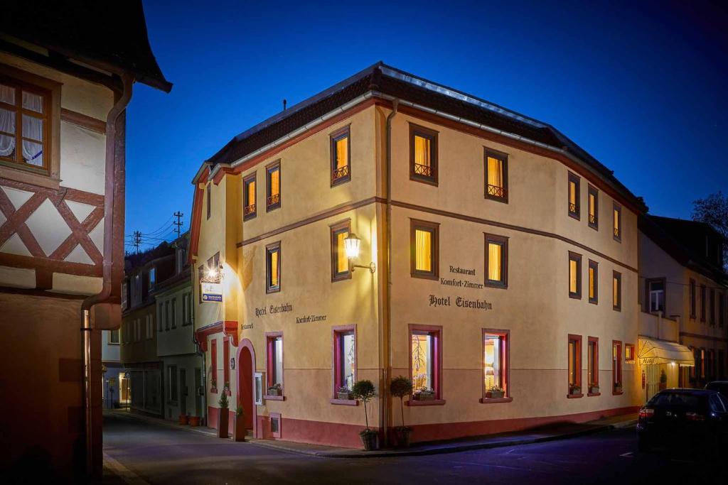 a large building is lit up at night at Hotel Eisenbahn in Karlstadt