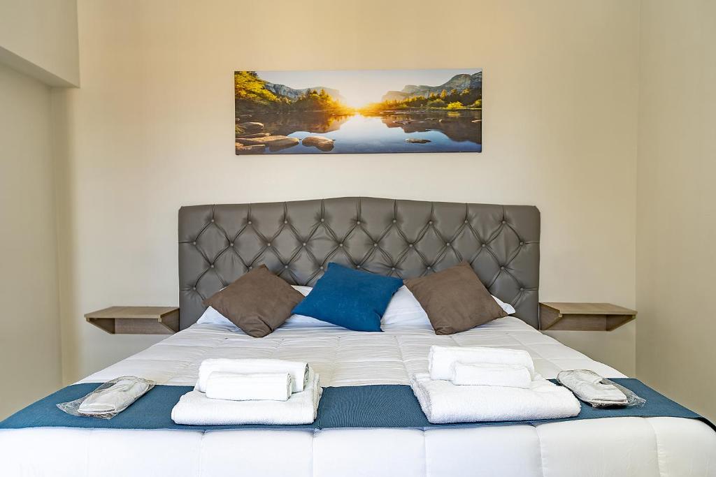 ein Schlafzimmer mit einem großen Bett mit blauen und weißen Kissen in der Unterkunft Il Falco in Reggio di Calabria