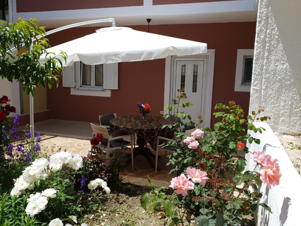 馬拉瑟亞斯的住宿－ANGELIKA HOUSE 1，天井配有带雨伞和鲜花的桌子