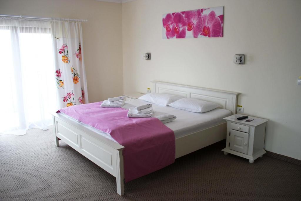 1 dormitorio con cama blanca y manta rosa en Pensiunea Casa Iorgovanul Urseni, en Timisoara