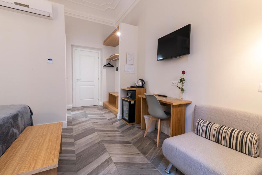 Televízia a/alebo spoločenská miestnosť v ubytovaní Eccelso Hotel