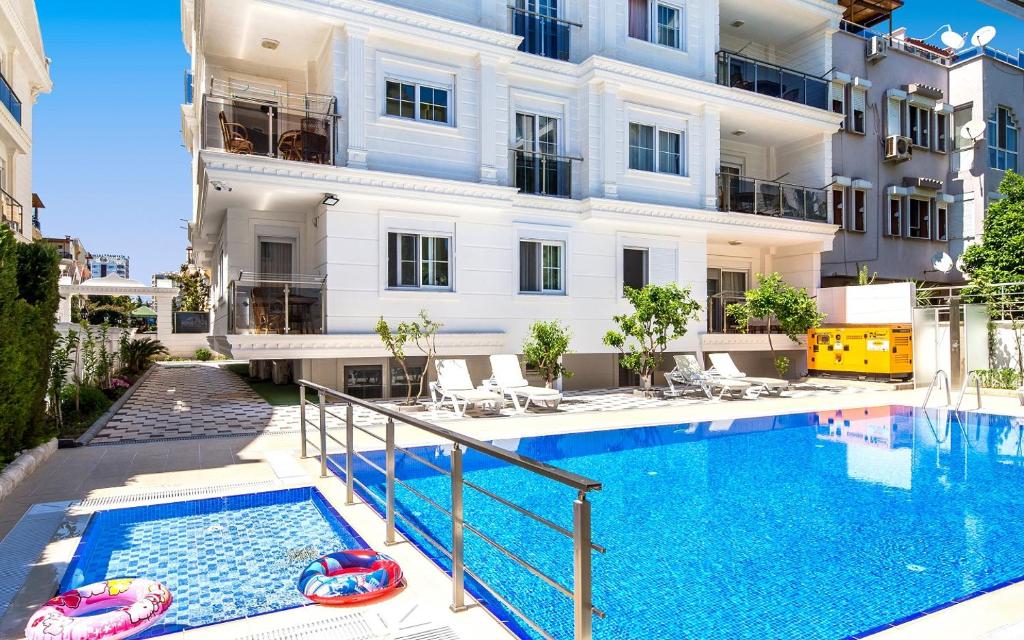 un apartamento con piscina frente a un edificio en Roma Residence - Emir Gürsu Evleri, en Antalya