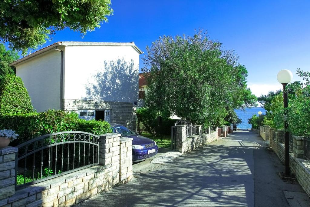 eine Straße mit einem Auto neben einem Gebäude in der Unterkunft Villa Palma in Petrcane