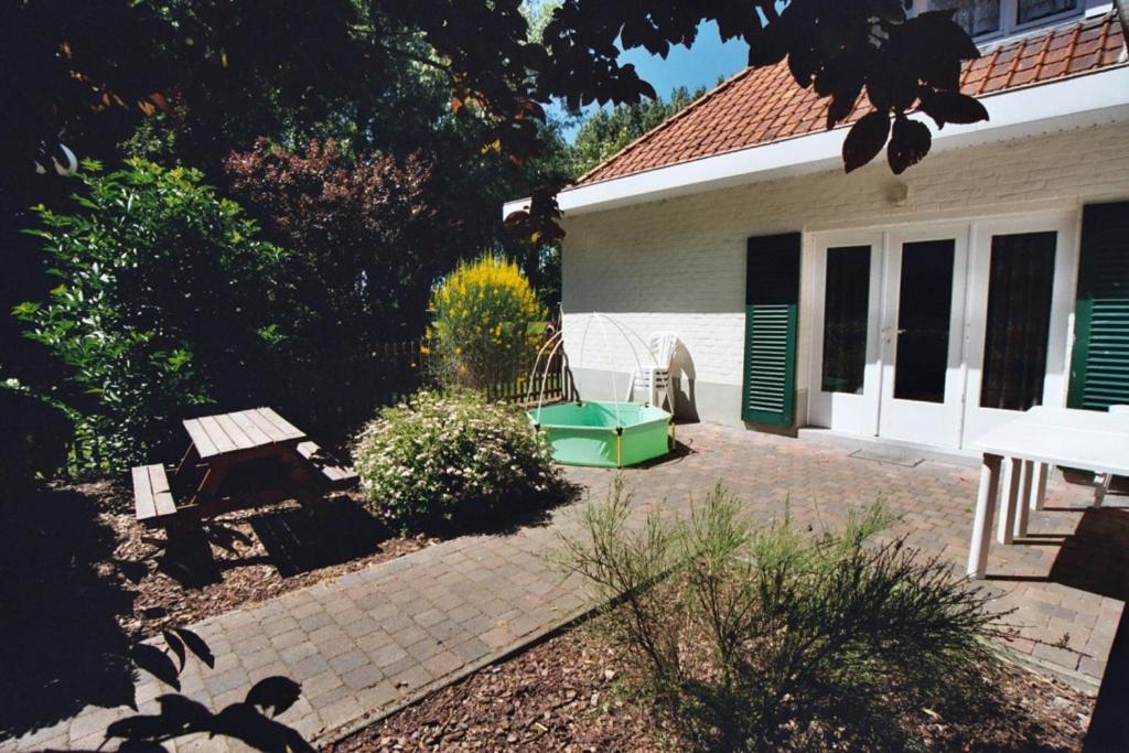 einen Hinterhof mit einem Picknicktisch und einem Haus in der Unterkunft Appartement Dahlia Garden 8p in De Haan