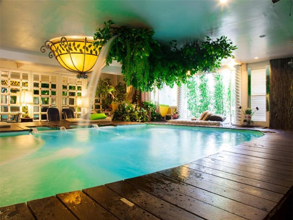 a large swimming pool in a living room at Diamond City Hotel SHA Certified in Bangkok