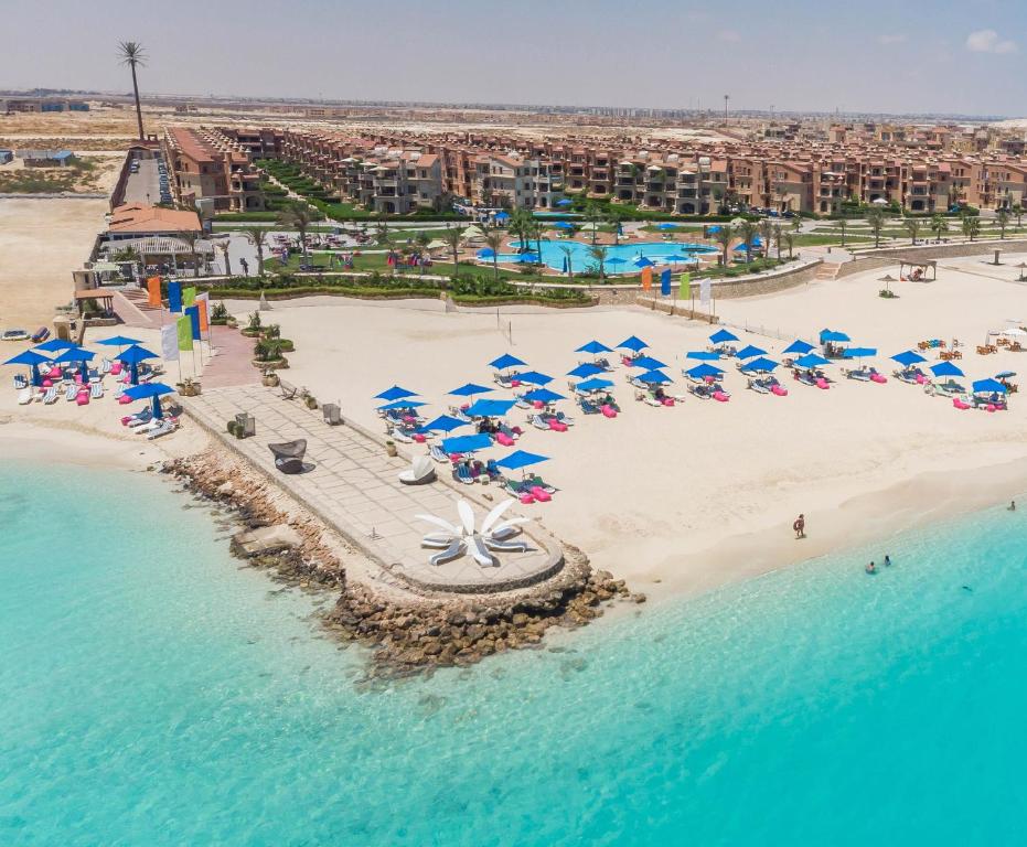 uma vista aérea de uma praia com guarda-sóis e do oceano em Mirage Hotel Sidi Abd El Rahman em El Alamein