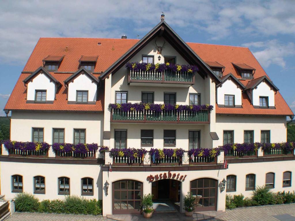 un gran edificio blanco con flores en los balcones en Goldener Hirsch, en Burgthann