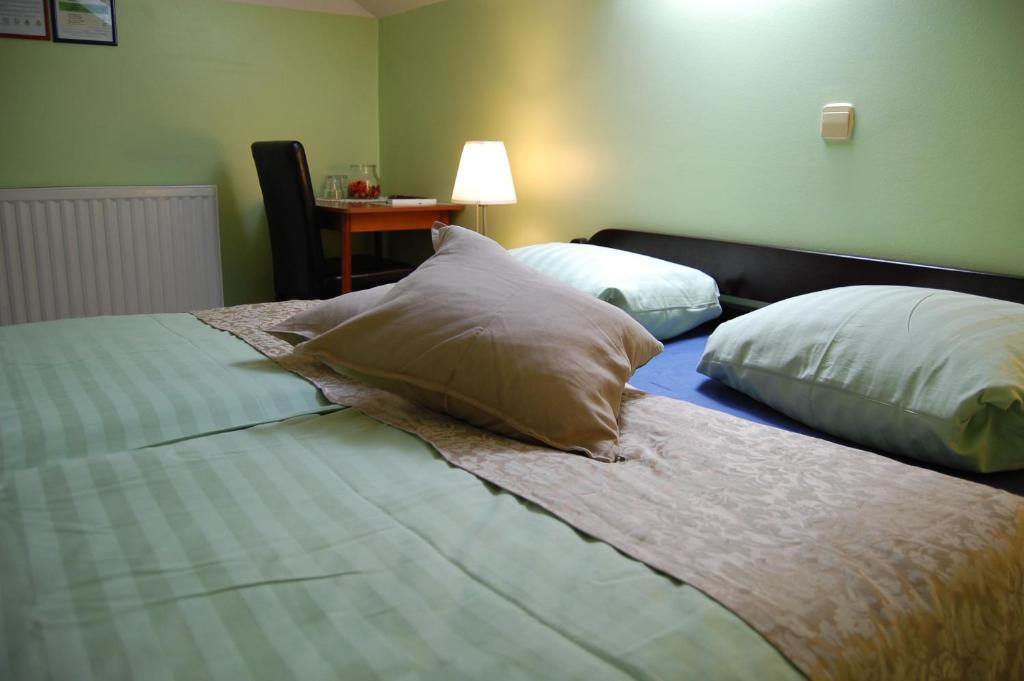 a bedroom with two beds with pillows and a table at Rooms Hiša Divino in Ptuj