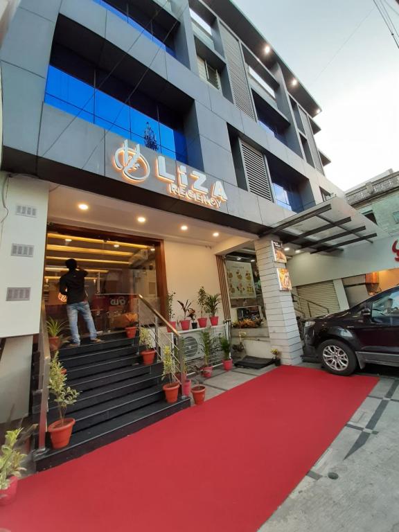 a man standing outside of a building with a red carpet at Liza Regency in Chennai
