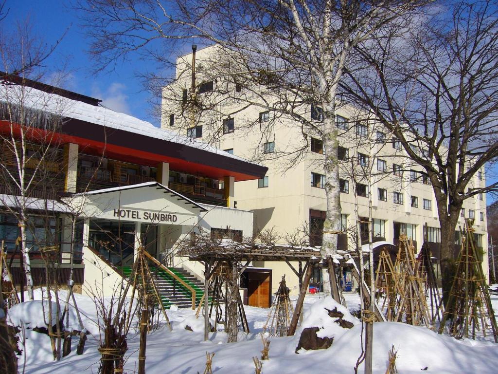 a hotel in the snow in front of a building at Hotel Sunbird in Minakami