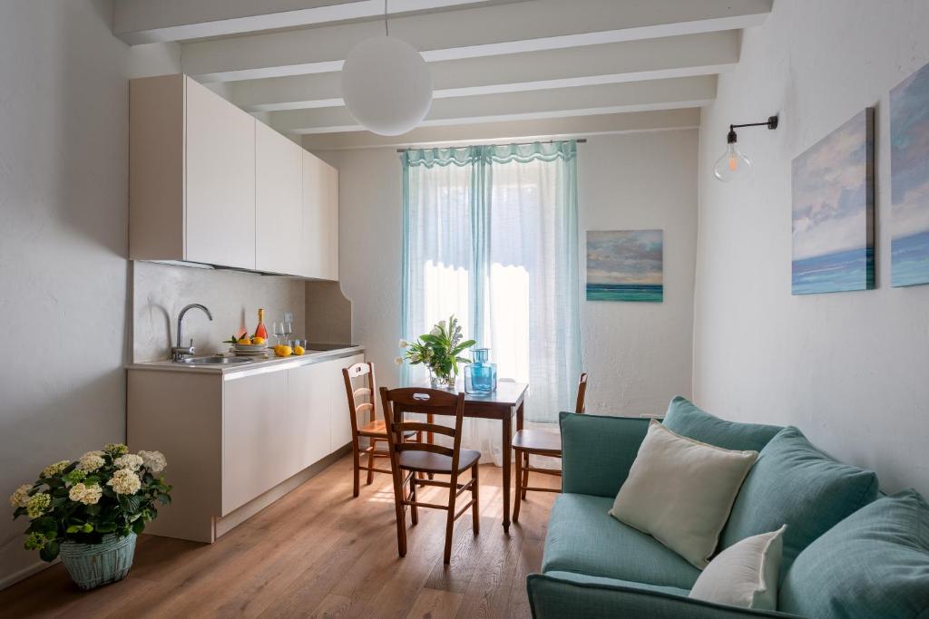 バルドリーノにあるRambaldi Apartments Casa nr 4 without Gardenのリビングルーム(緑のソファ付)、キッチンが備わります。