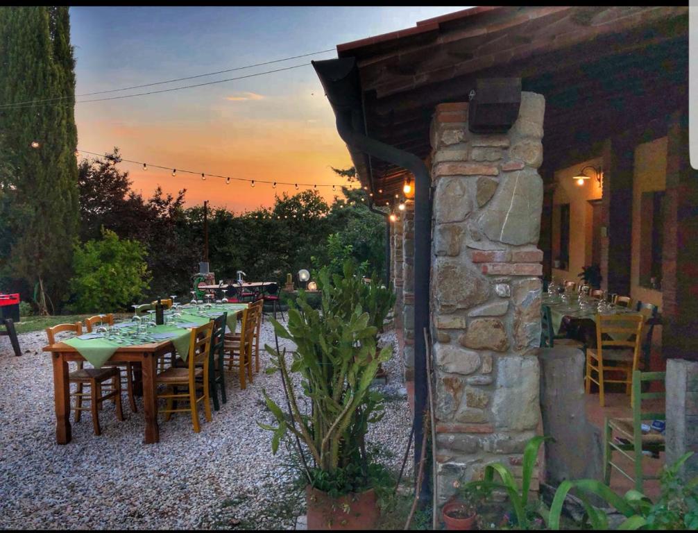 a patio with tables and chairs and a stone building at Agriristoro Podere S. Andrea in Massa Marittima