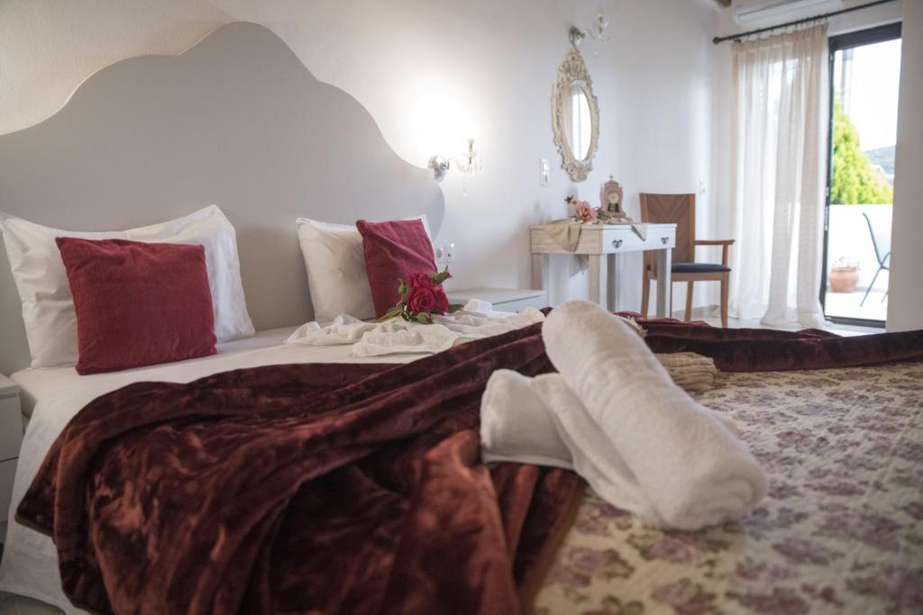 a bedroom with a large bed with red and white pillows at Studio Galatia in Kamilari
