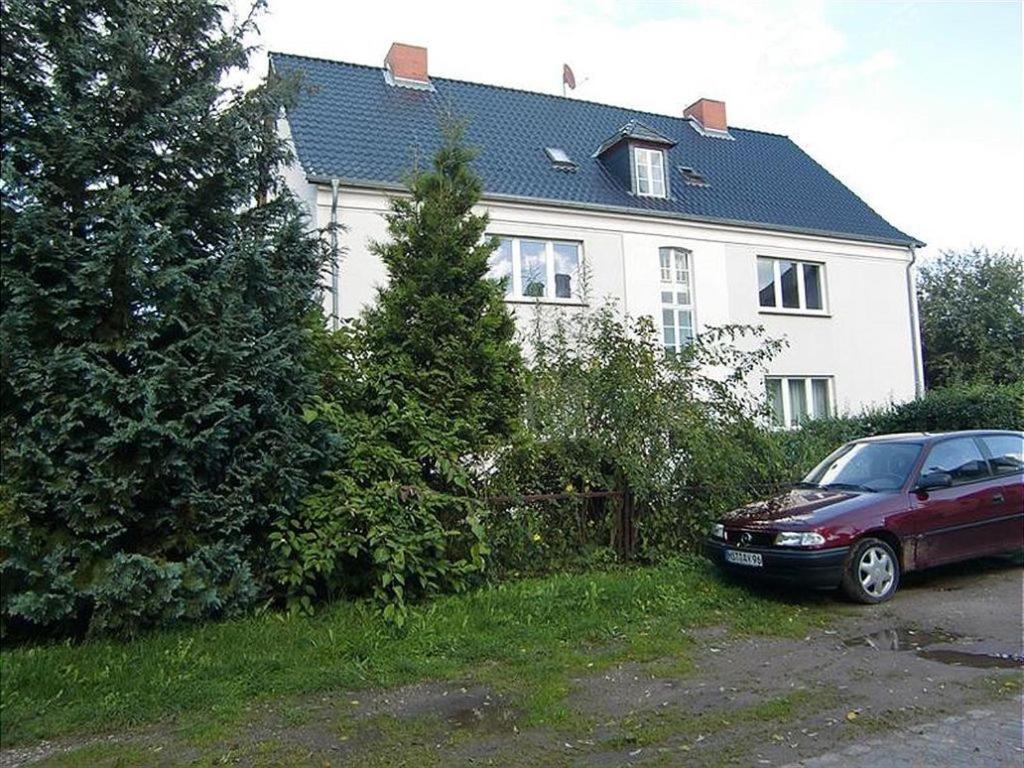 un coche rojo estacionado frente a una casa en Ferienwohnung A0, en Klocksin