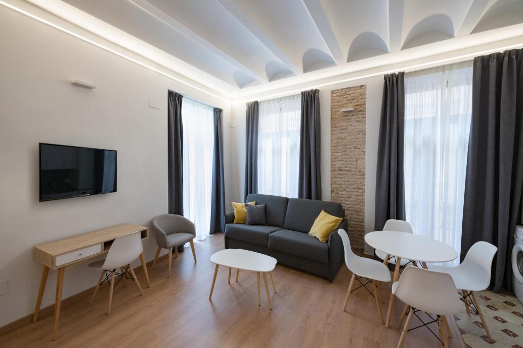 a living room with a couch and a table and chairs at Old Town Flats Casa Burguerini in Valencia