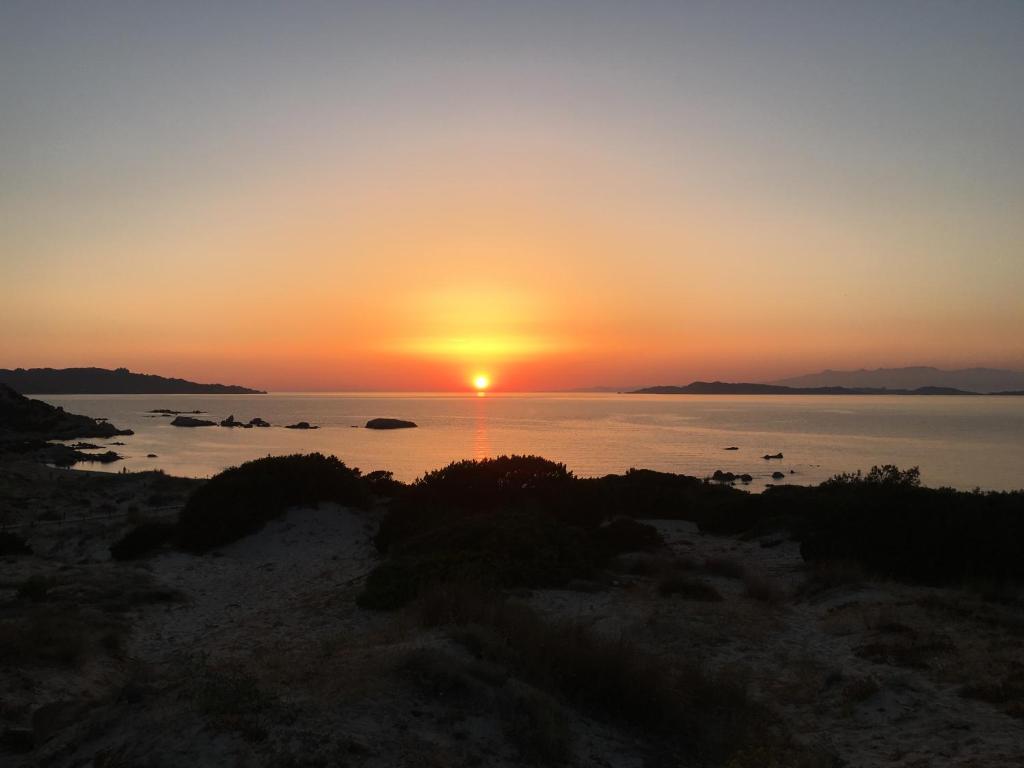 a sunset over the water with the sun setting at Dimora Conte in La Maddalena