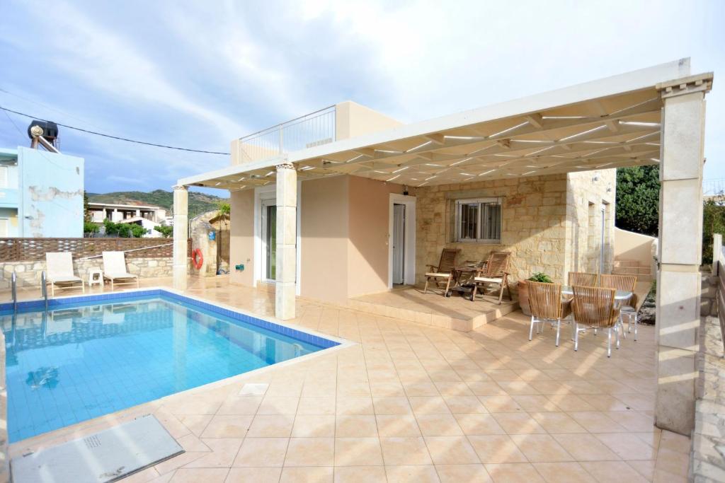 een villa met een zwembad en een huis bij Villa Nopigia Mare in Kissamos