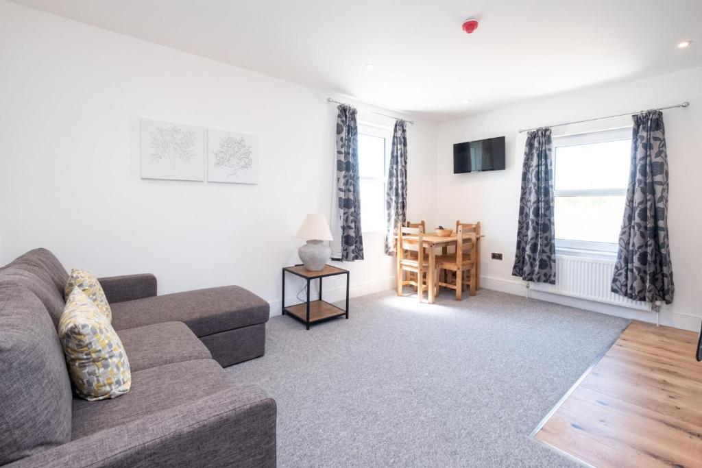 a living room with a couch and a table at Rowan – Three Tuns Apartments in Pettistree