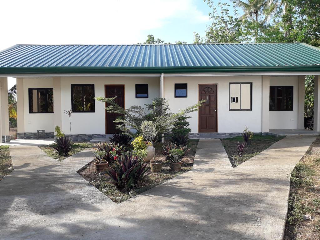 a small white house with a green roof at Gal's Guesthouse in Siquijor