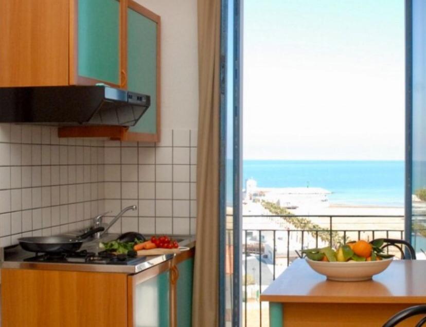 a kitchen with a bowl of fruit on a counter next to a window at Residence Ducale in Rodi Garganico