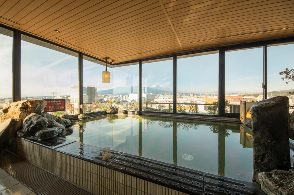 una gran piscina de agua en un edificio con ventanas en Dormy Inn Mishima, en Mishima