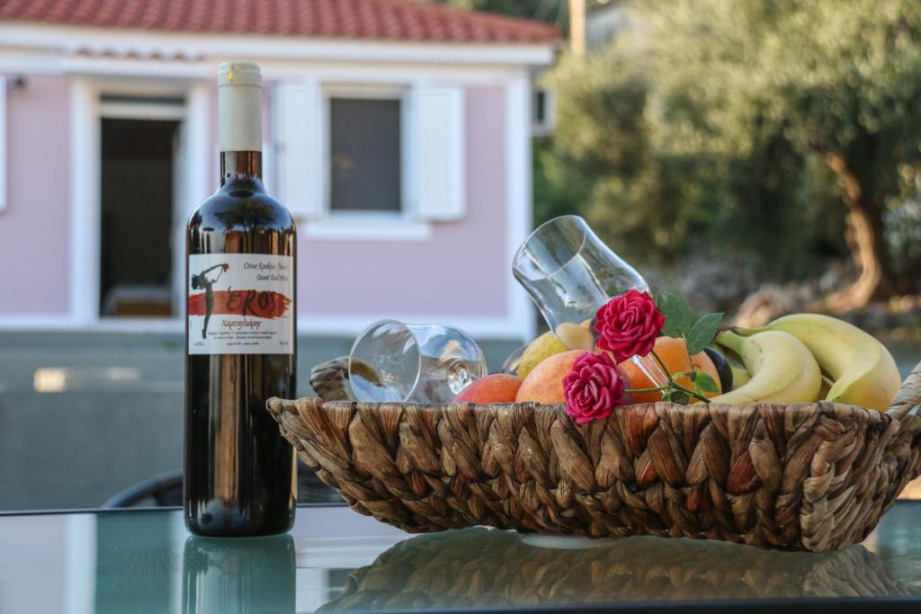 uma garrafa de vinho ao lado de uma cesta de frutas em La Casa di Odyssey em Dhavgáta