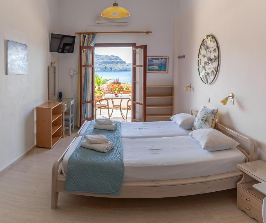 a bedroom with two beds and a view of the ocean at Eleni Goumenaki Plakias Studios in Plakias