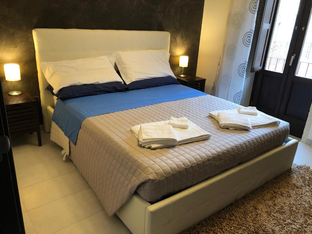 - une chambre avec un lit et des serviettes dans l'établissement Spirduta di Levante, à Syracuse