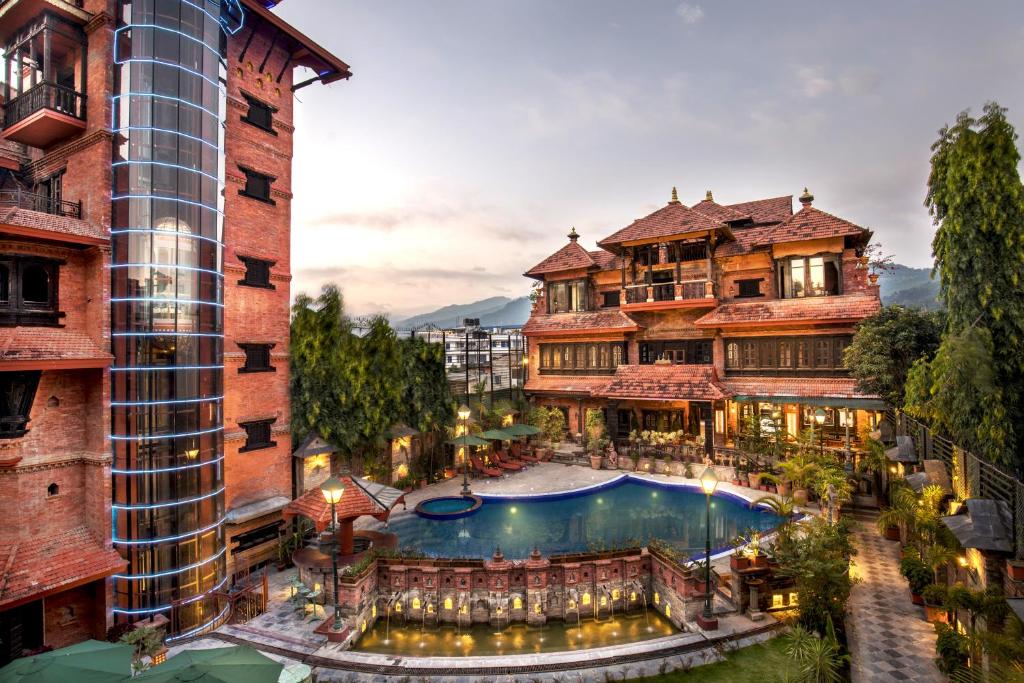 ein Hotel mit einem Swimmingpool vor einem Gebäude in der Unterkunft Heritage Hotel Suites and Spa in Pokhara