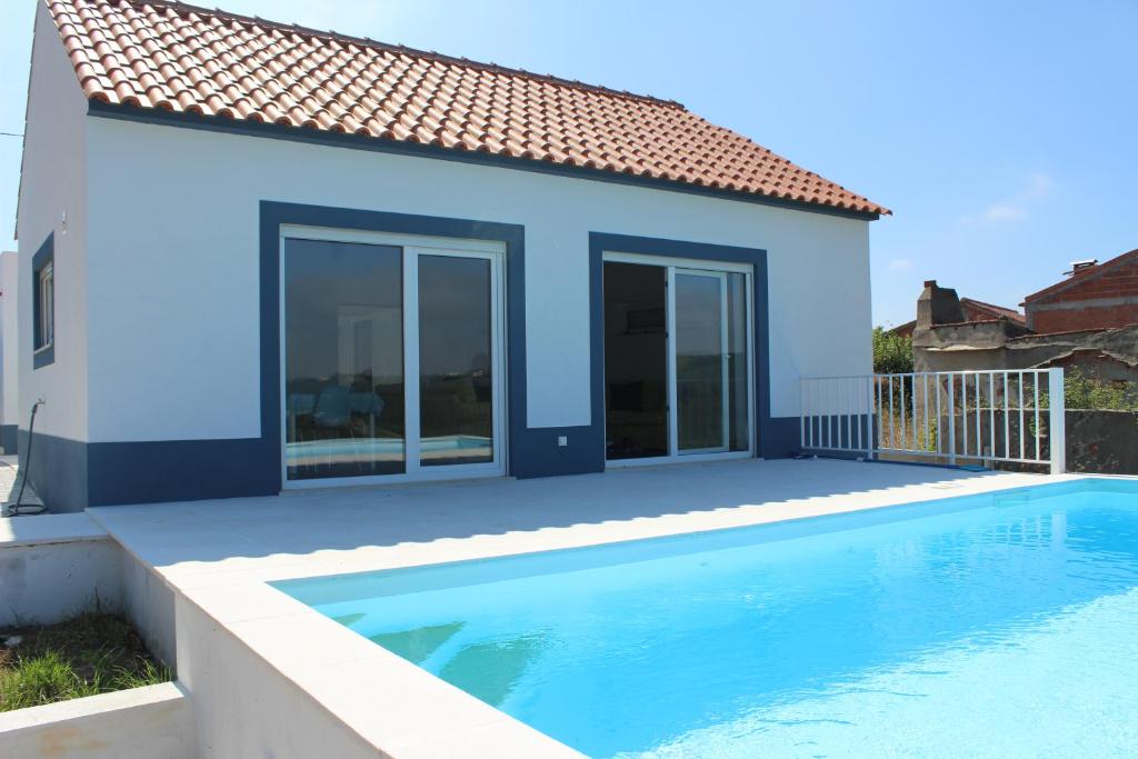 une maison bleue avec une piscine en face de celle-ci dans l'établissement Villa Ricardo, à Alcobaça