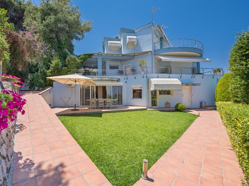 una gran casa blanca con césped delante en Aegean Residence - F & B Summer Collection, en Kallithea Halkidikis