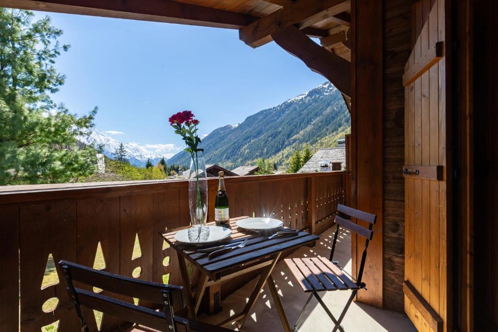 a table and chairs on a balcony with a view at Village des Oursons Chalet B - Happy Rentals in Chamonix-Mont-Blanc