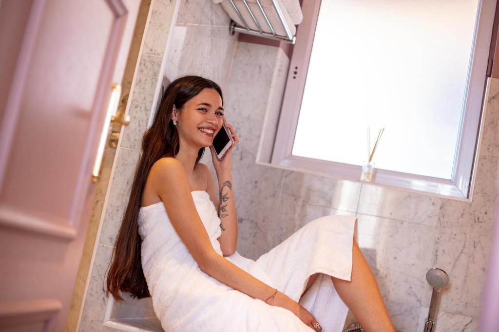 a woman in a white dress talking on a cell phone at Le Cavendish in Cannes