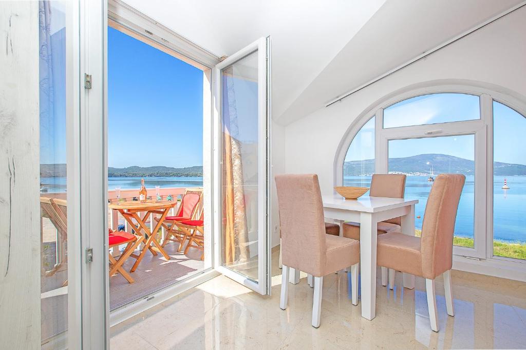 una sala da pranzo con tavolo e vista sull'oceano di Apartments Infinity a Tivat