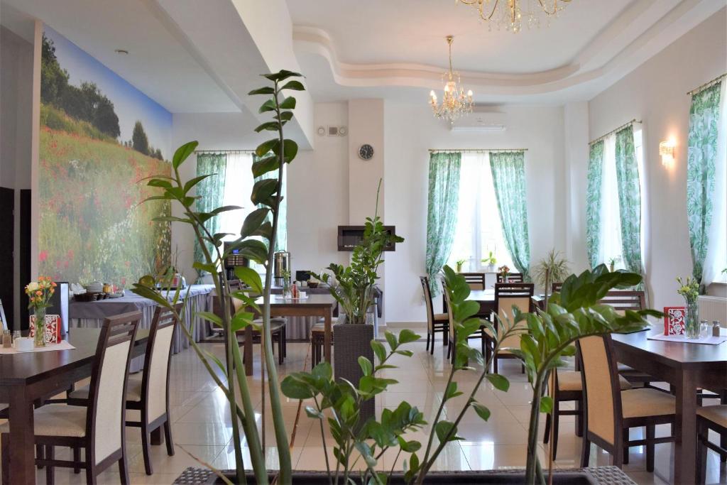 une salle à manger avec des tables et des plantes en pot dans l'établissement Hotel Złotogórski, à Kościelec