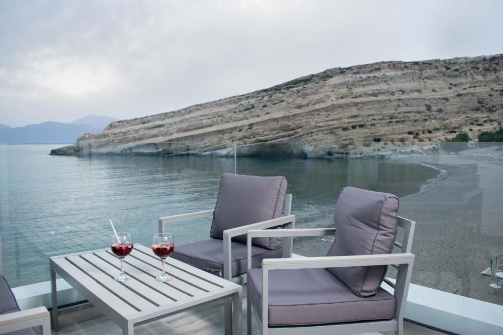 two glasses of wine sitting on a table on a boat at Thalasso resort in Matala