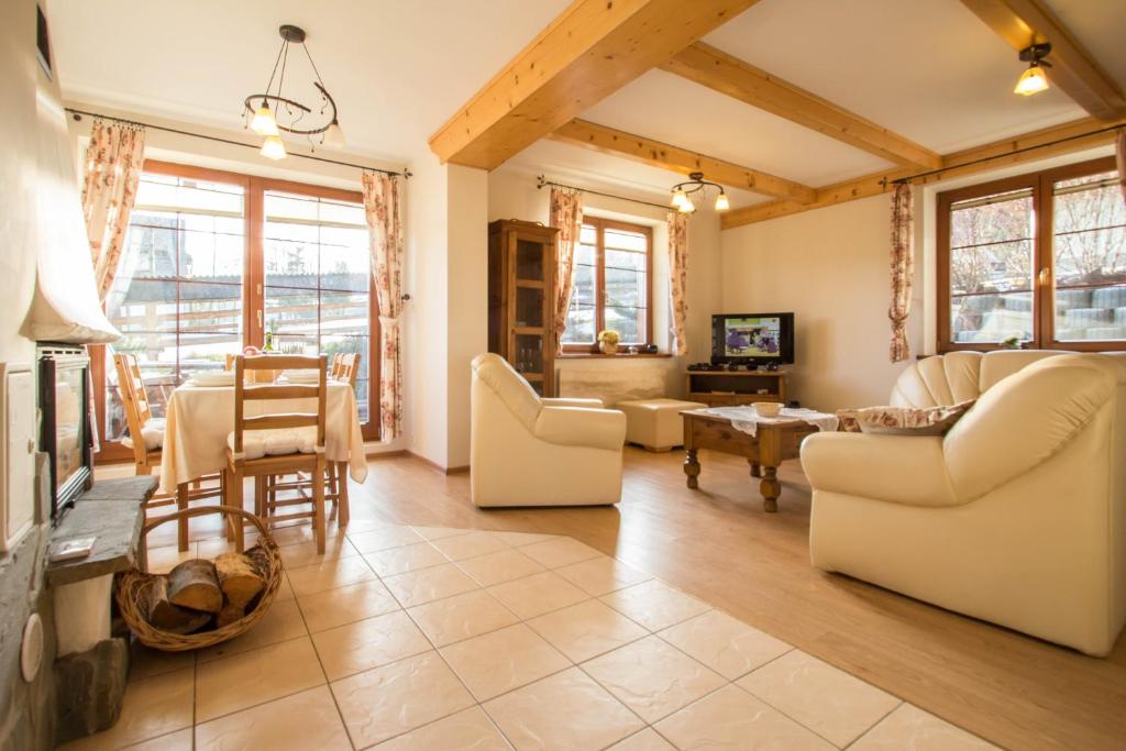 a living room with white furniture and a table at Domek Osada Gubałówka Zakopane in Słodyczki