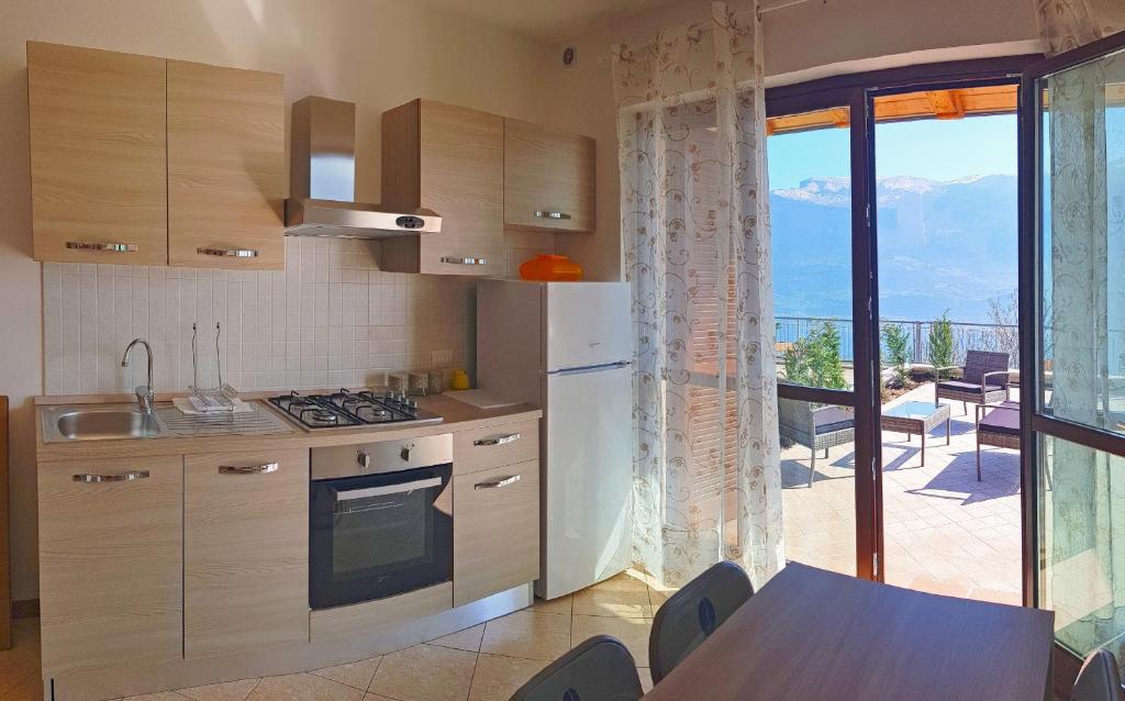 een keuken met een tafel en uitzicht op een patio bij La Quiete 27 Lake view by Gardadomusmea in Tremosine Sul Garda
