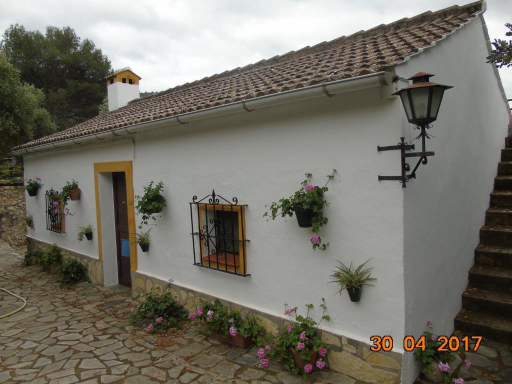 Una casa blanca con flores a un lado. en CASA EL CERRO, en El Bosque