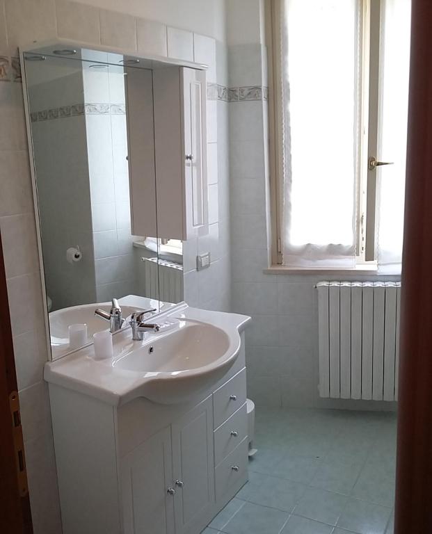 a white bathroom with a sink and a mirror at Casa della Nonna 2 in Gargnano