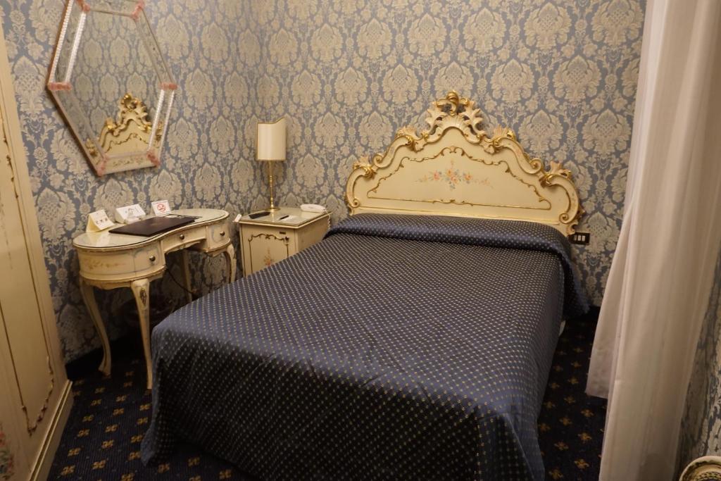 a small bedroom with a bed and a sink at Hotel Rialto in Venice