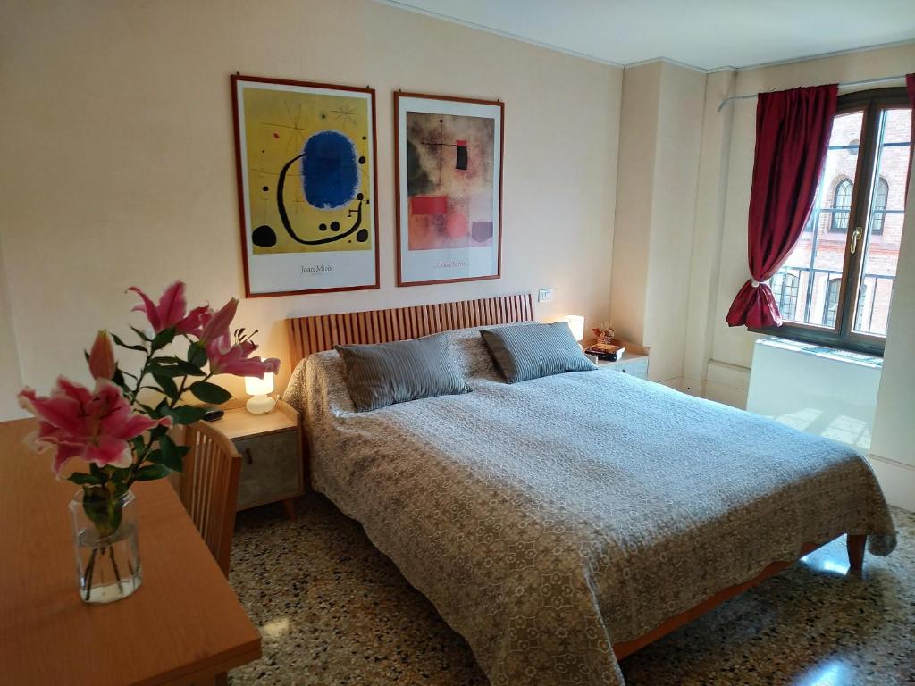 a bedroom with a bed and a vase of flowers at Apartment in Molino Stucky in Venice