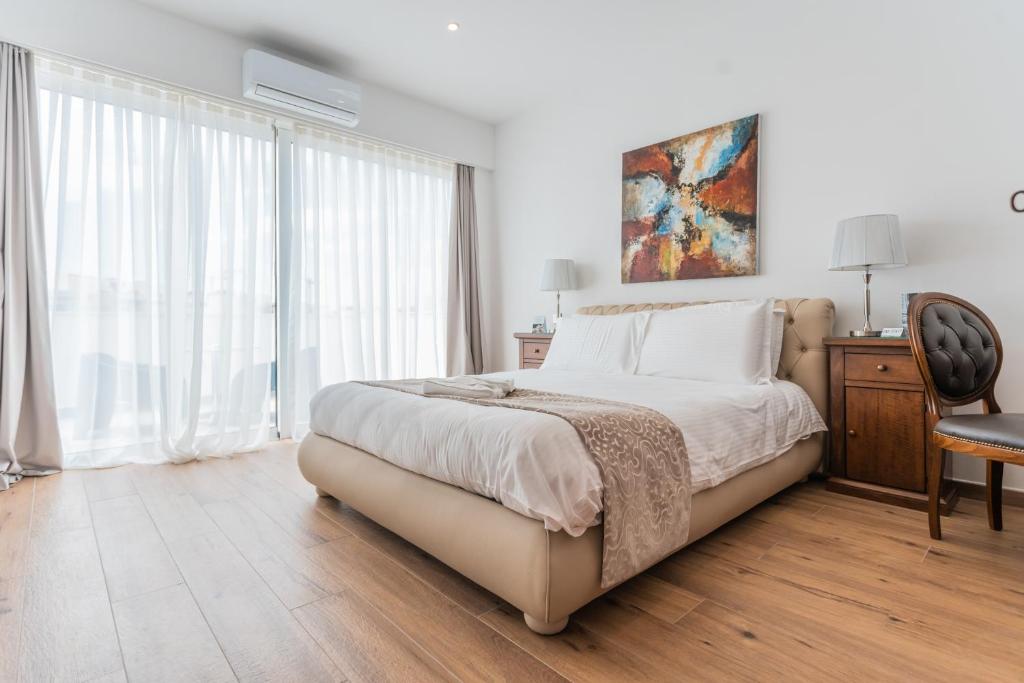 a bedroom with a bed and a desk and a window at Palazzo Violetta in Sliema