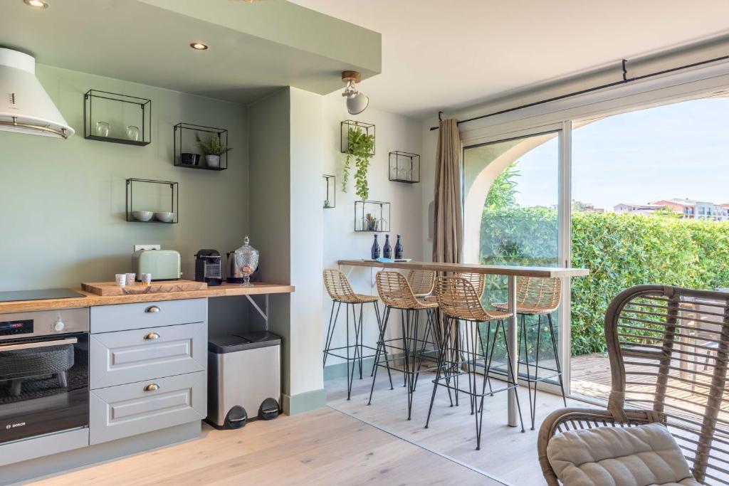 a kitchen with a counter and a bar with chairs at Green Suite Golfe de Saint Tropez in Gassin