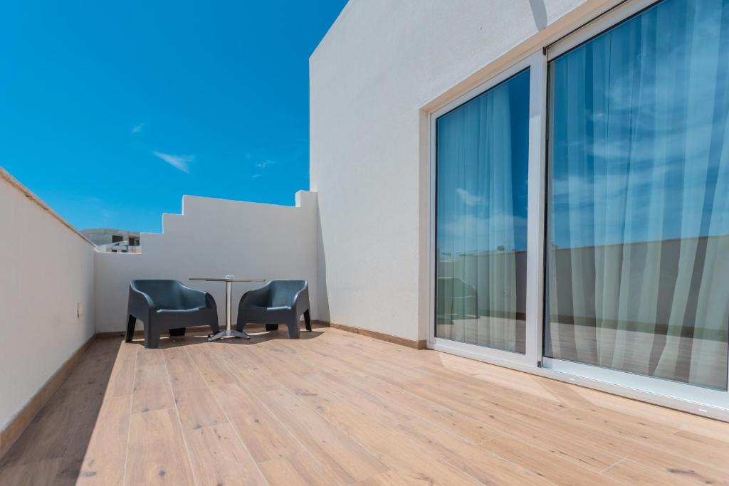 a dining room with a table and chairs on a balcony at Palazzo Violetta in Sliema