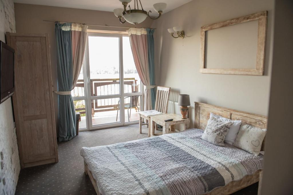 1 dormitorio con 1 cama y ventana con balcón en Apartamenty Faust, en Ełk