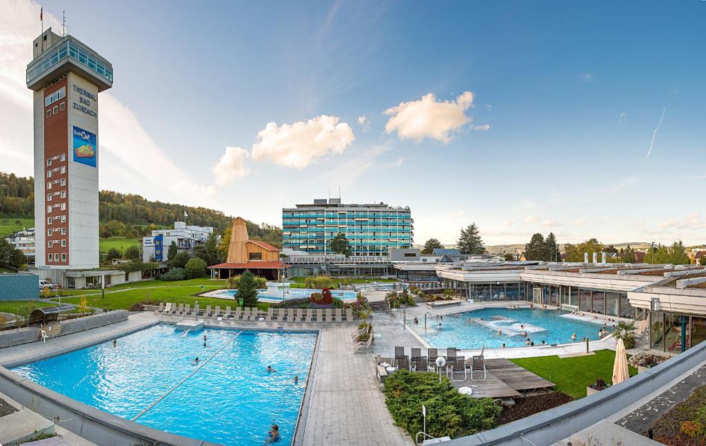 un complexe avec 2 piscines et un bâtiment dans l'établissement VitalBoutique Hotel Zurzacherhof, à Bad Zurzach