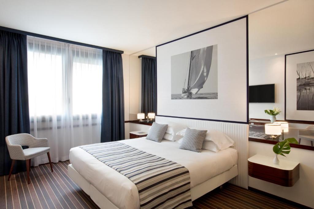 a hotel room with a large bed and a large window at Starhotels President in Genoa